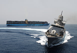 ship on body of water near cargo ship during daytime