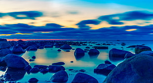 rock formation beside body of water during sun set HD wallpaper