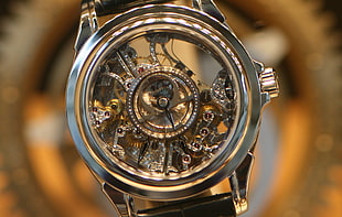round gold-colored skeleton watch with black leather strap, watch, luxury watches, Omega (watch)