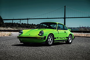 green Porsche Carrera on black asphalt road HD wallpaper