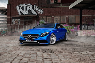 blue Mercedes-Benz CL-class parked on bricked surface during daytime