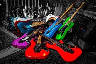 several assorted-color electric guitars