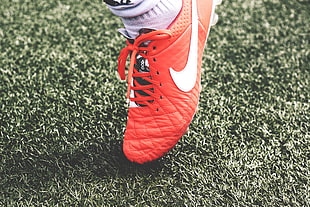 person wearing red and white Nike cleat