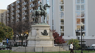 ma riding horse statue near building