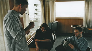 three men in a room talking to each other