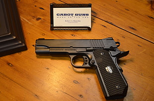 black semi-automatic pistol near white box