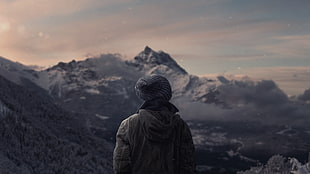 person wearing knit hat looking at mountain
