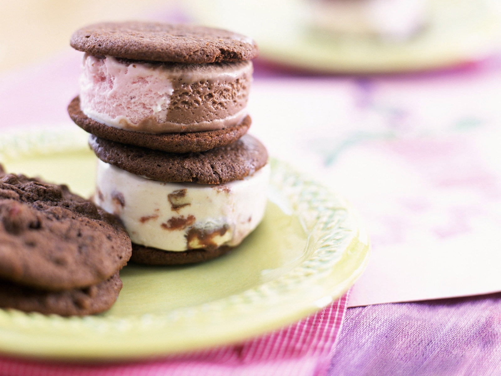 chocolate macaron over another macaron on yellow plate