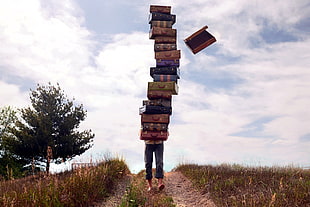 assorted-title textbooks, men outdoors, men, suitcase