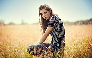 woman wearing striped top on bed of green grasses