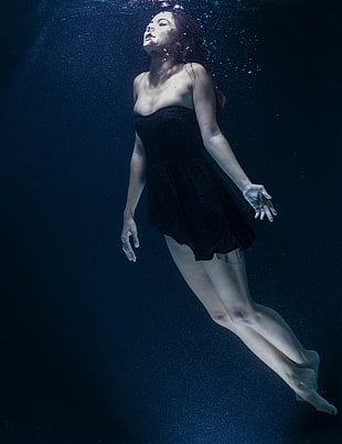 woman wearing black strapless doll dress in underwater