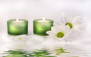 two green glass candle holders with tealights