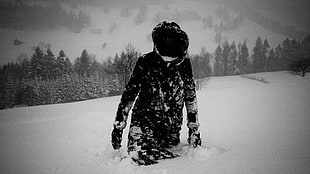 person wearing black hoodie standing on snow