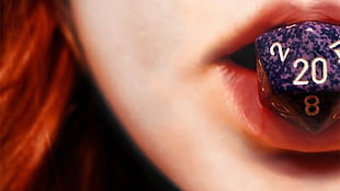 woman in pink lipstick with dice on mouth