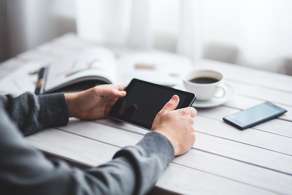 person holding black tablet computer HD wallpaper