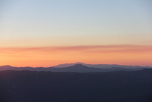 photo of sunset view of mountain with brown clear sky