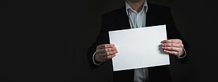 man holding white sheet of paper