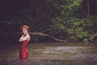 woman wearing red sleeveless dress in body of water