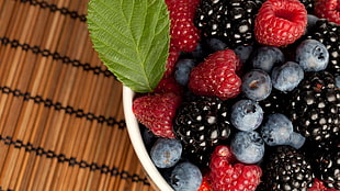 close-up photo of assorted berries on white bowls