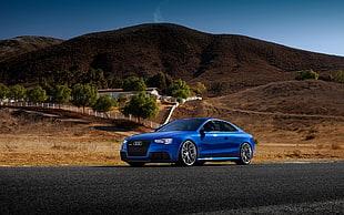 blue Audi sedan on asphalt road