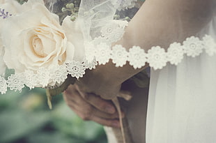 bride holding bouquet of white roses