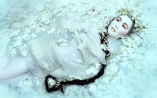 lying woman surrounded with white petals and braided hair photo