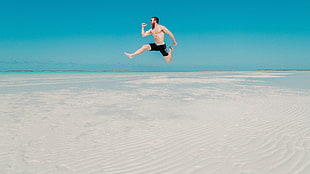 men's black shorts, photography, beach, jumping, skinny