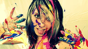 woman splat with paints beside white wall