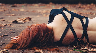 woman lying on ground surrounded with leaves