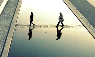 two man walking on road during daytime
