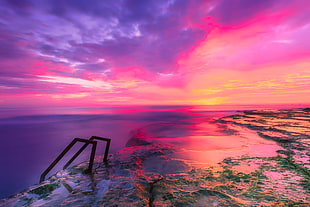 landscape photography of rock surface with water during golden hour