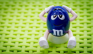 blue M&M figurine holding head