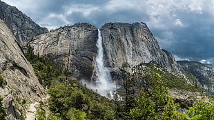 photography of waterfalls between mountain