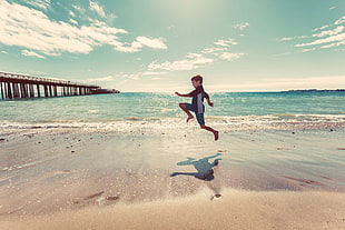 boy running near the seashore during daytime HD wallpaper