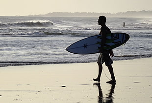 man holding white surfboard