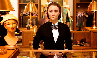 woman in black suit jacket standing in front of display cabinet