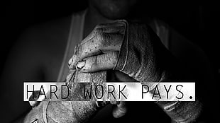 grayscale photo of man holding his fist with Hard Work Pays. text overlay