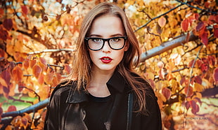 woman wearing black zip-up leather jacket with black framed wayferer eyeglasses