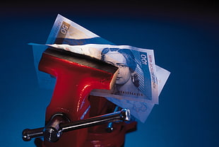 banknote gripped on red bench vise