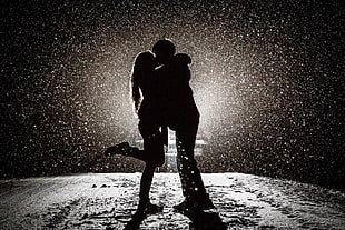 photo of man and woman under the rain during night time