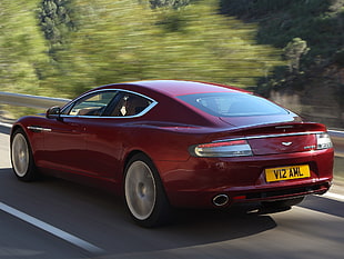 red Aston Martin Vanquish on gray concrete road during daytime