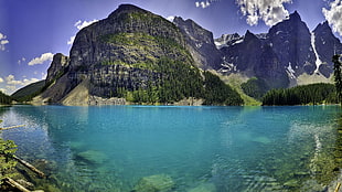 panorama photography of blue sea water with rock mountain background