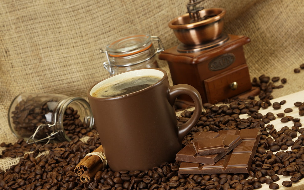 filled brown ceramic mug beside chocolate bar HD wallpaper