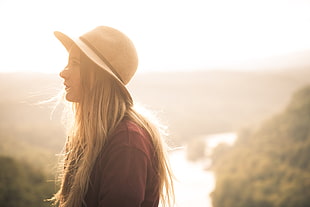 woman in maroon sweater and brown sunhat in selective focus photography