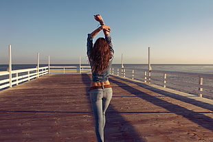 woman walking on a dock raising her hands