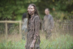 woman with zombie outfit stands on grass field