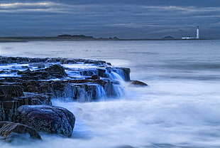 body of water near to rock cliff photo HD wallpaper