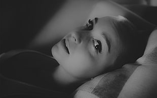 gray scale of woman lying on bed