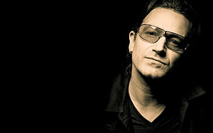 landscape portrait photo of man wearing black framed sunglasses and black v-neck shirt