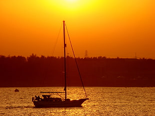 gray sailboat on body of water during golden hour